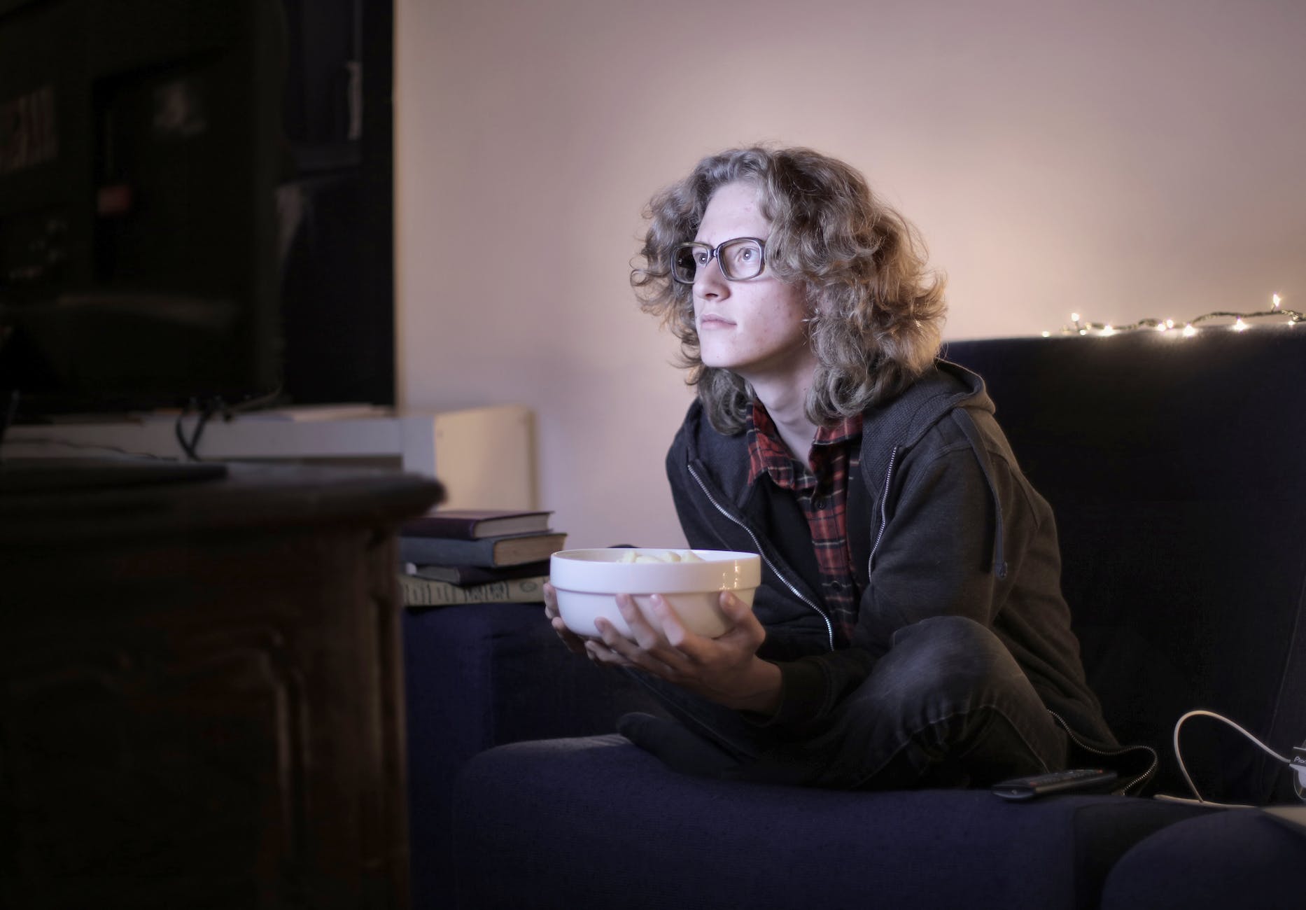 interested teenager watching tv with popcorn